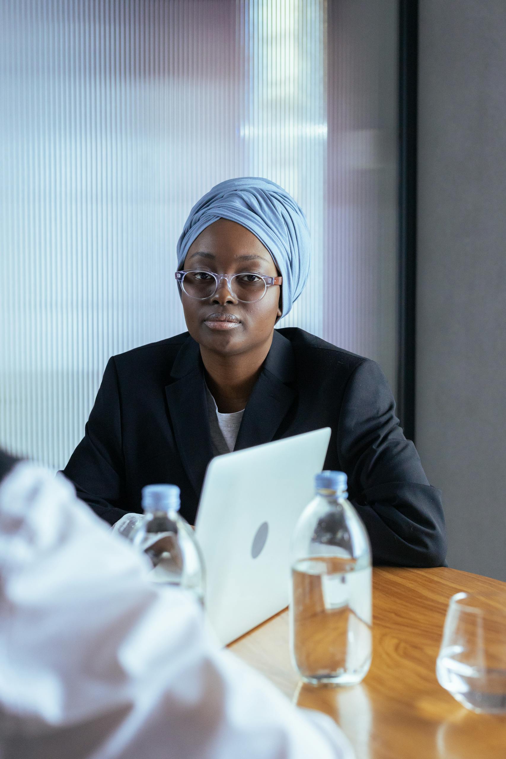African businesswoman wearing headscarf using laptop during an office meeting.