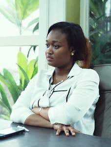 Confident businesswoman in an office setting with plants, embodying modern elegance.