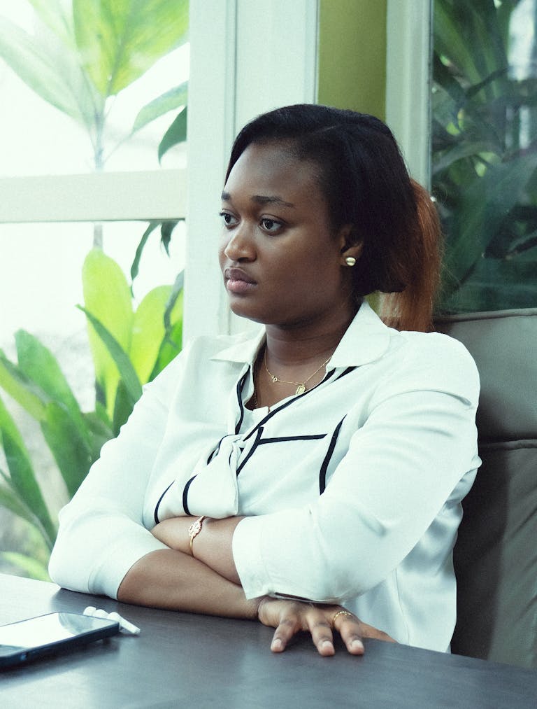 Confident businesswoman in an office setting with plants, embodying modern elegance.